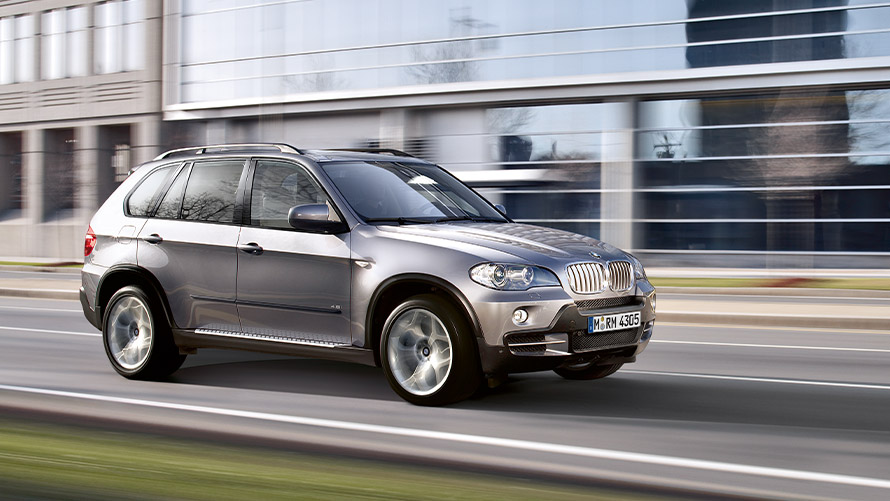 BMW X5 E70 druga generacja widok z boku podczas jazdy na ulicy Modele BMW X BMW X5 E70 druga generacja widok z boku podczas jazdy na ulicy