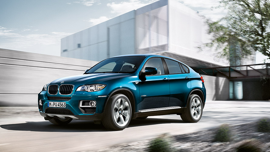 BMW X6 E71 pierwsza generacja półprofil podczas postoju na tle budynku Modele BMW X BMW X6 E71 pierwsza generacja półprofil podczas postoju na tle budynku