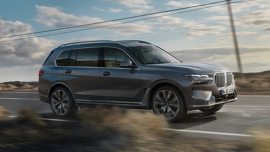 BMW X7 G07 pierwsza generacja tylny półprofil podczas jazdy na ulicy Modele BMW X BMW X7 G07 pierwsza generacja tylny półprofil podczas jazdy na ulicy