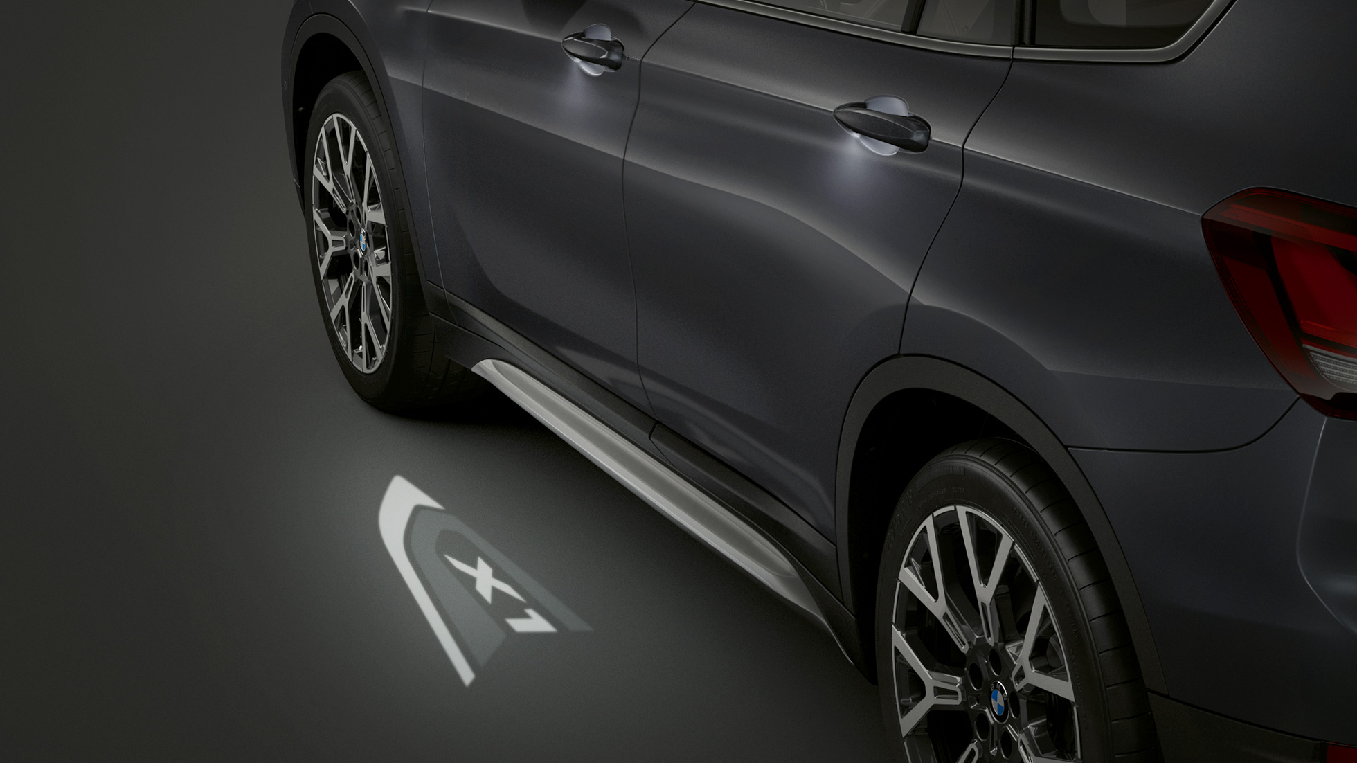 BMW X1, wyświetlany napis „X1”. BMW X1, widok z boku skupiony na wyświetlanym napisie „X1”.