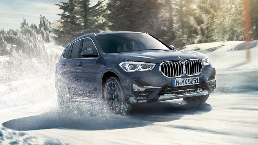 BMW X1 xDrive20i F48 LCI Storm Bay BMW Individual metalizowany podczas jazdy na zimowym tle BMW X1 xDrive20i F48 LCI Storm Bay BMW Individual metalizowany podczas jazdy na zimowym tle