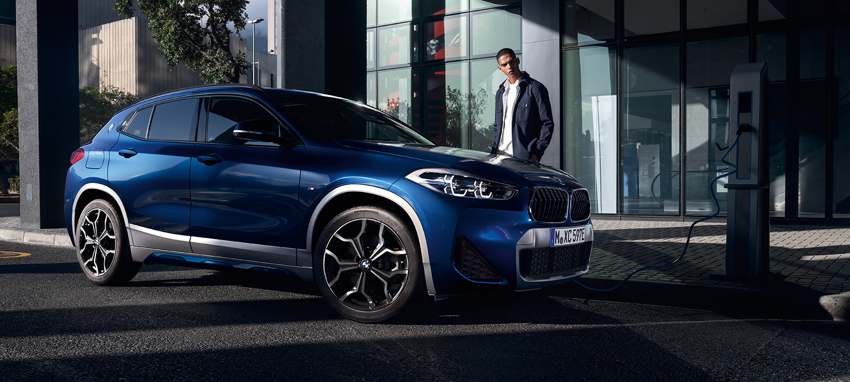 Hybryda plug-in BMW X2 xDrive25e F39 półprofil przy stacji ładowania Hybryda plug-in BMW X2 xDrive25e F39 półprofil przy stacji ładowania z modelem