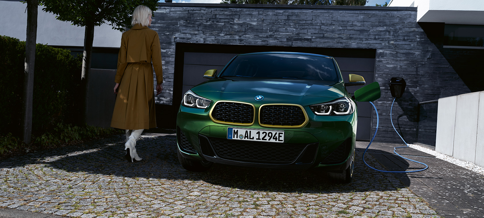 Widok z przodu BMW X2 F39 zieleń San Remo metalizowany Widok z przodu podczas ładowania z modelem po lewej stronie BMW X2 F39 zieleń San Remo metalizowany