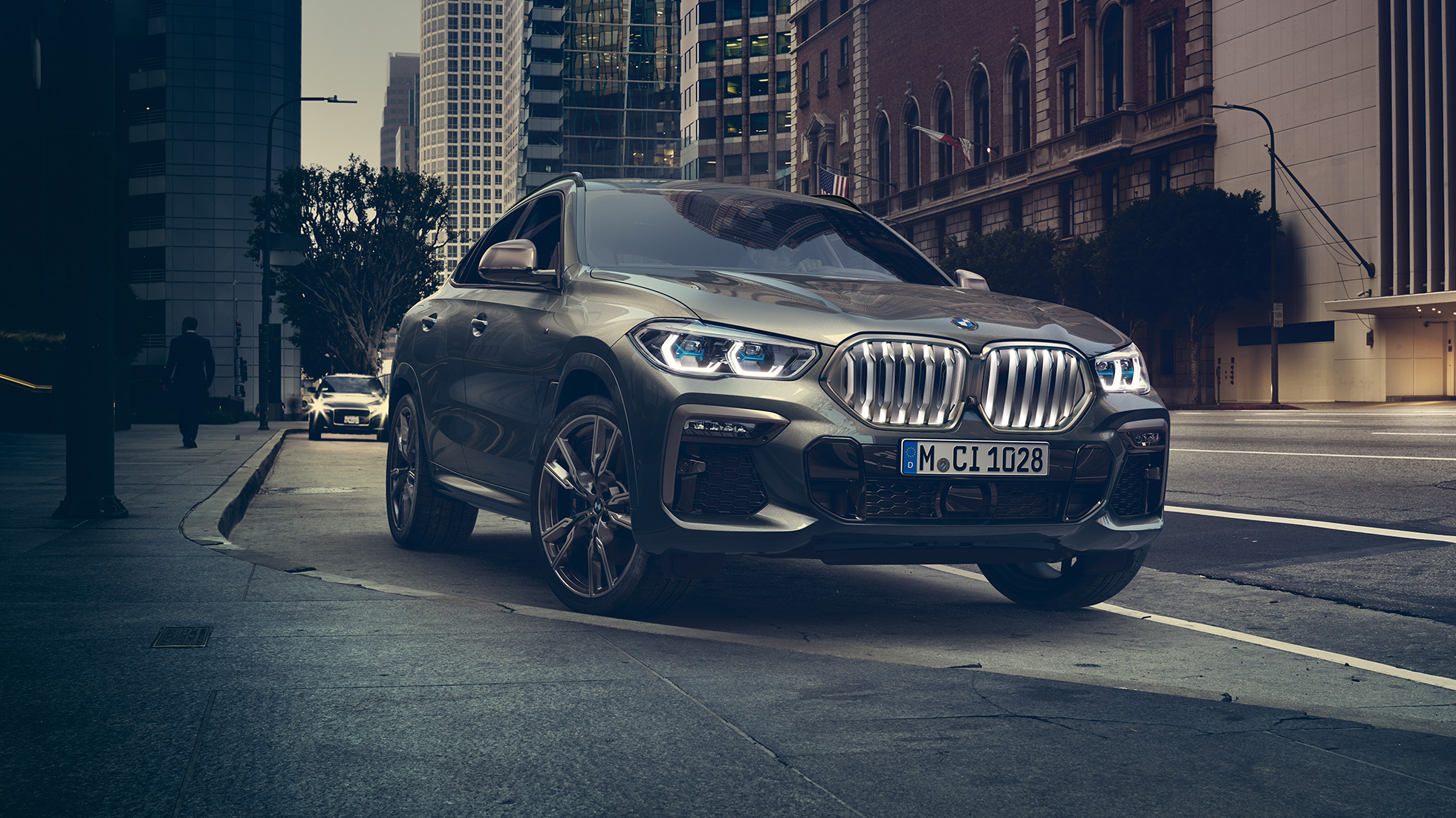 Adaptacyjne zawieszenie BMW X6 M Professional BMW X6, ujęcie w półprofilu od przodu na tle scenerii miejskiej.