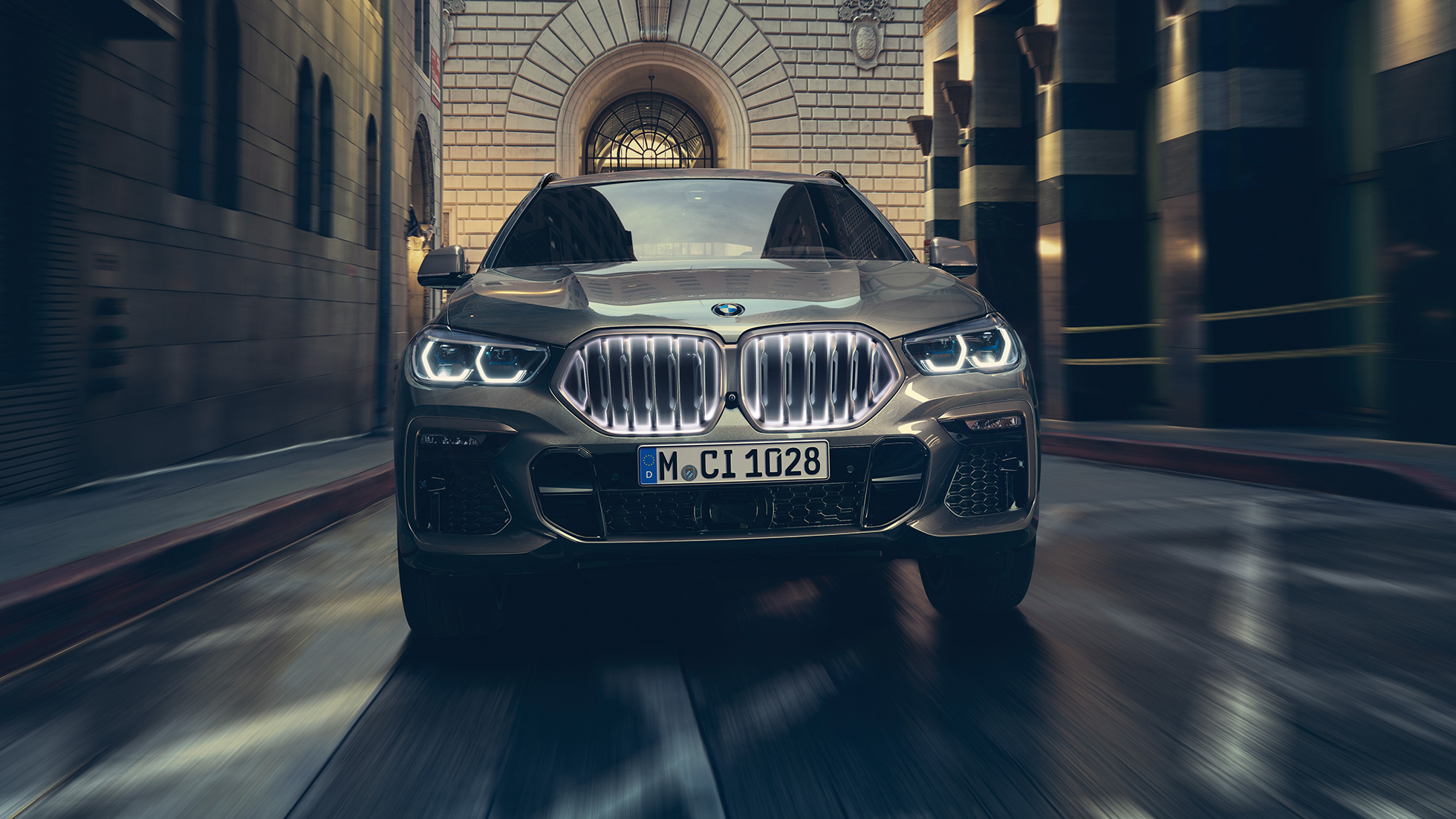 BMW X6 z atrapą chłodnicy BMW z efektem „Iconic Glow”. BMW X6 widoczny od przodu w scenerii miejskiej.
