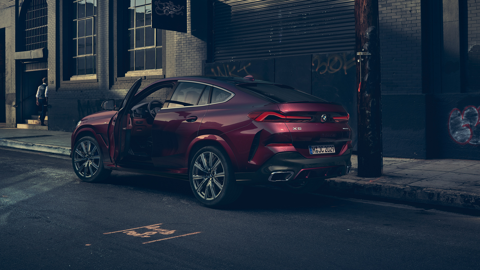 Widok BMW X6 Individual od tyłu. BMW X6 Individual stojący w miejscu w ujęciu z półprofilu od tyłu.