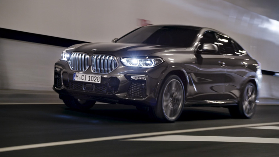 Przedni półprofil BMW X6 G06 2019 BMW X6 G06 2019 przedni półprofil podczas jazdy na tle miasta