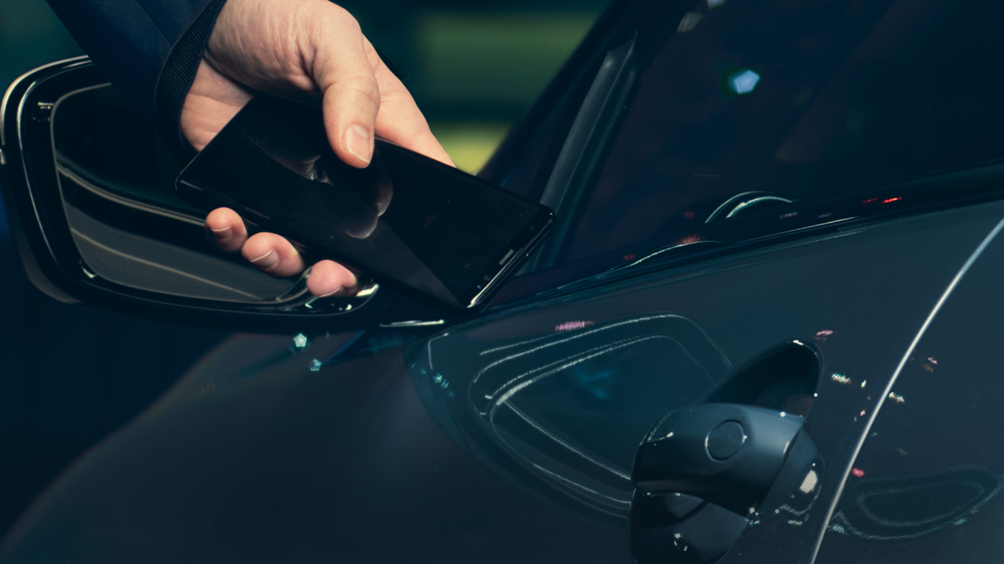 Digital Key Digital Key: mężczyzna przykłada smartfon z zewnątrz do drzwi pojazdu