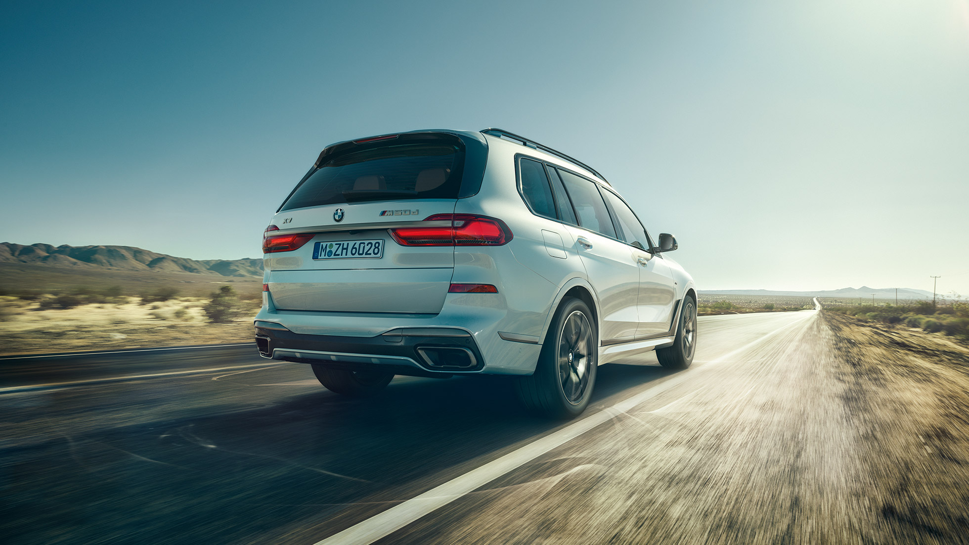 BMW X7 M50d, widok tyłu BMW X7 M50d: widok tyłu jadącego, białego BMW X7