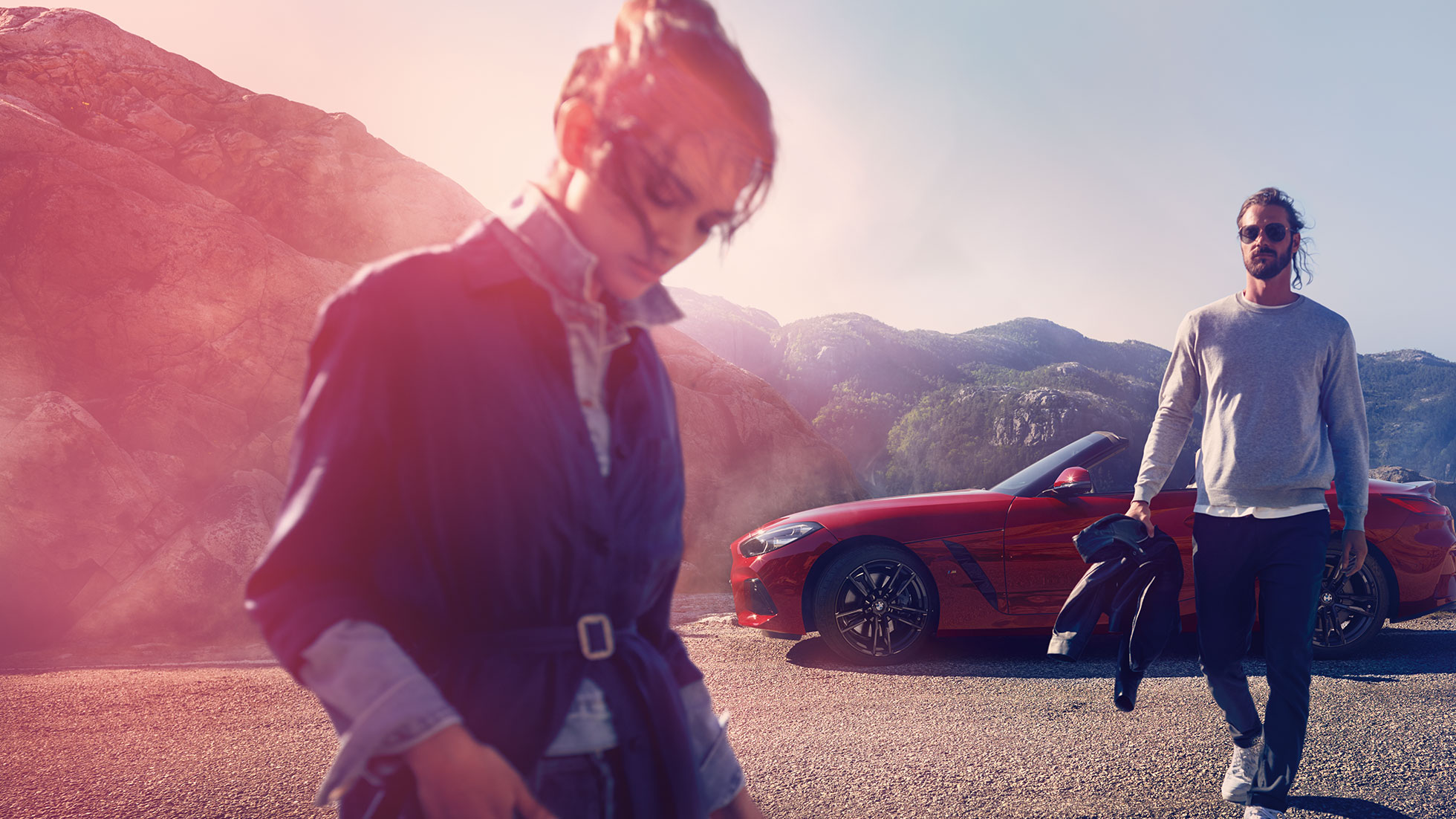 BMW Z4 Roadster na tle górskiego widoku Mężczyzna i kobieta i BMW Z4 Roadster na tle górskiego widoku
