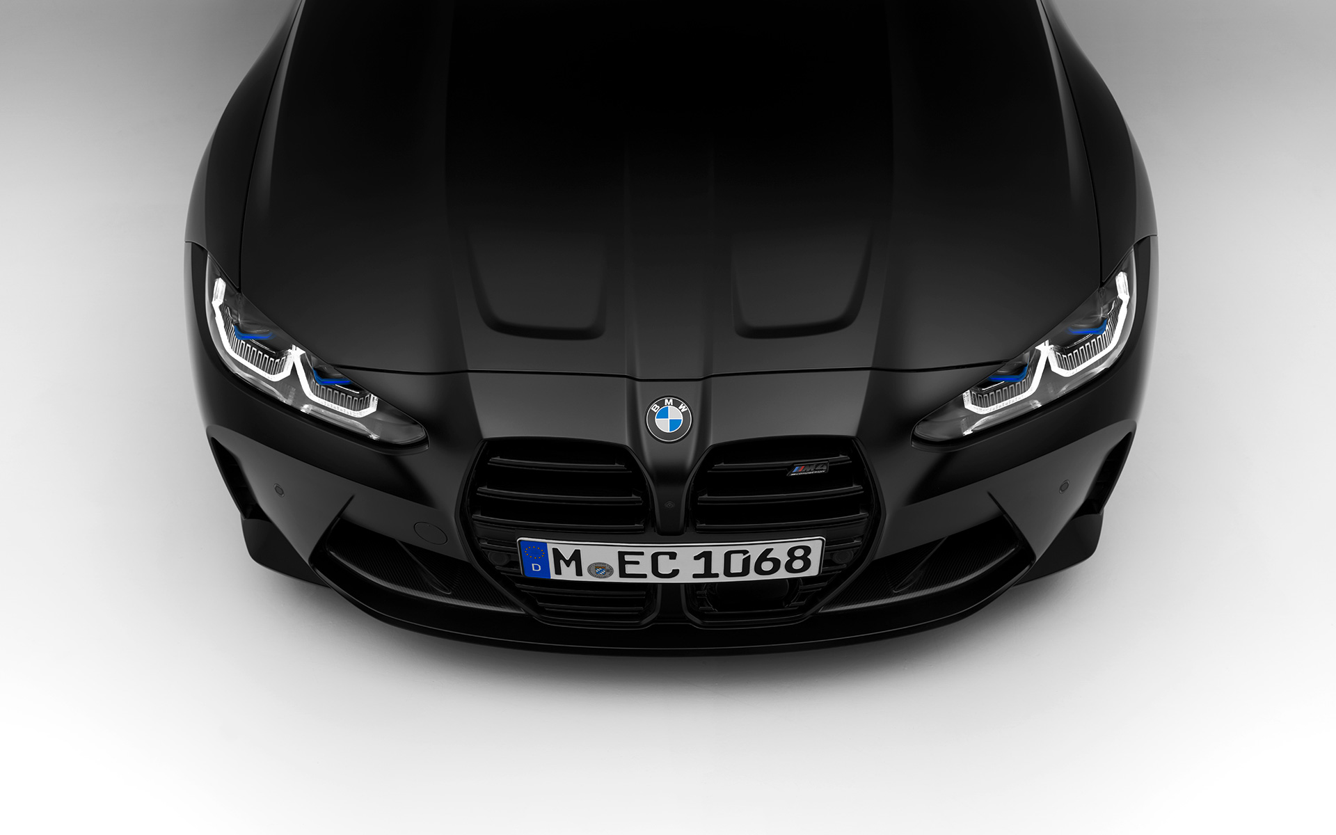 BMW M4 Competition Coupé G82 2021 mroźna czerń BMW Individual metalizowany widok z przodu BMW M4 Competition Coupé G82 2021 mroźna czerń BMW Individual metalizowany podczas postoju widok z przodu fragment z góry