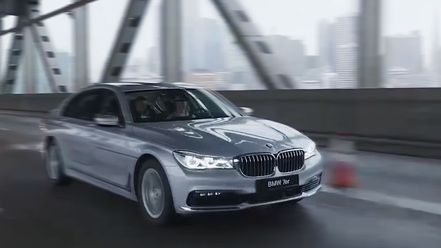 Ekran z grafiką nawigacyjną w BMW Szary BMW Serii 5 Sedan oznaczony z BMW Personal CoPilot jedzie z prawej strony na autostradzie.