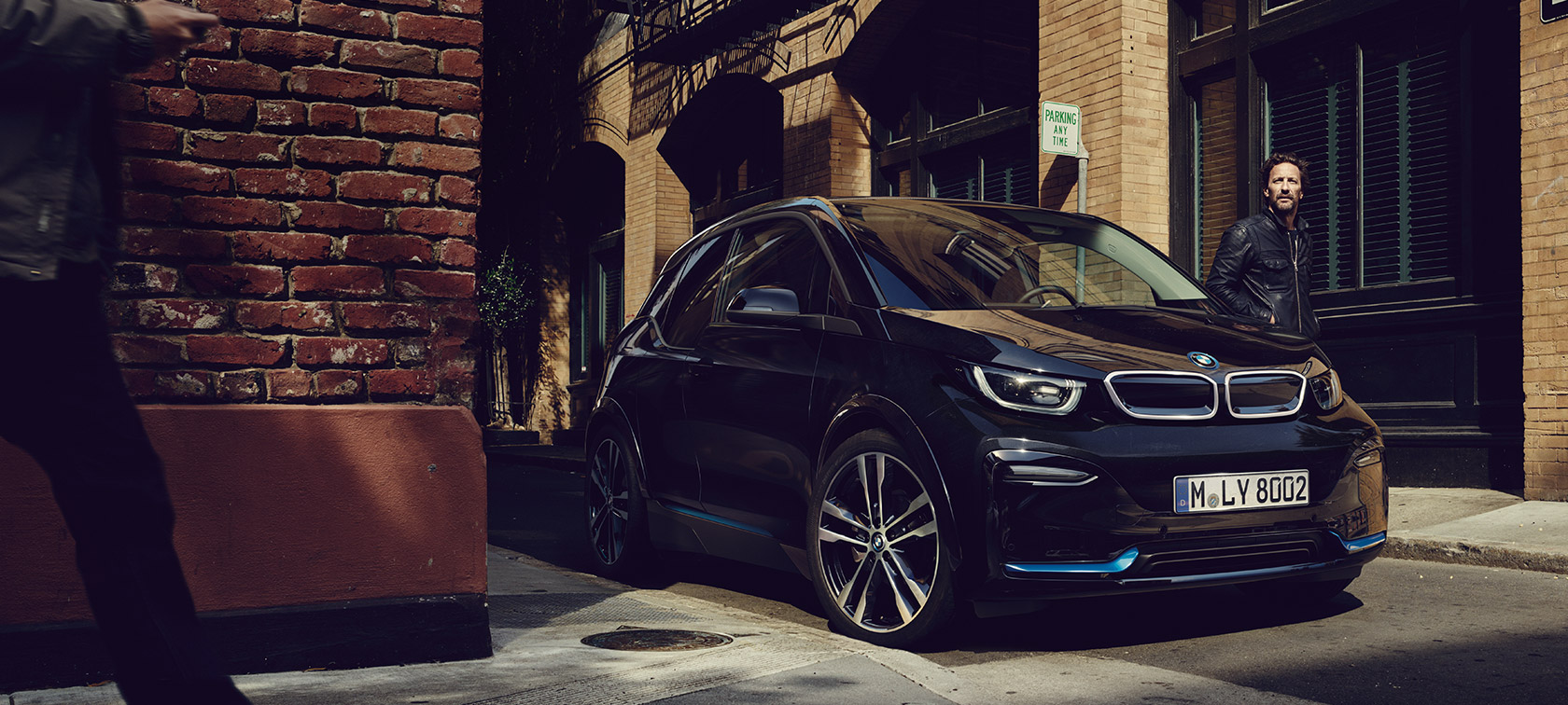 BMW i3. BMW i3 półprofil z przodu na tle miasta.