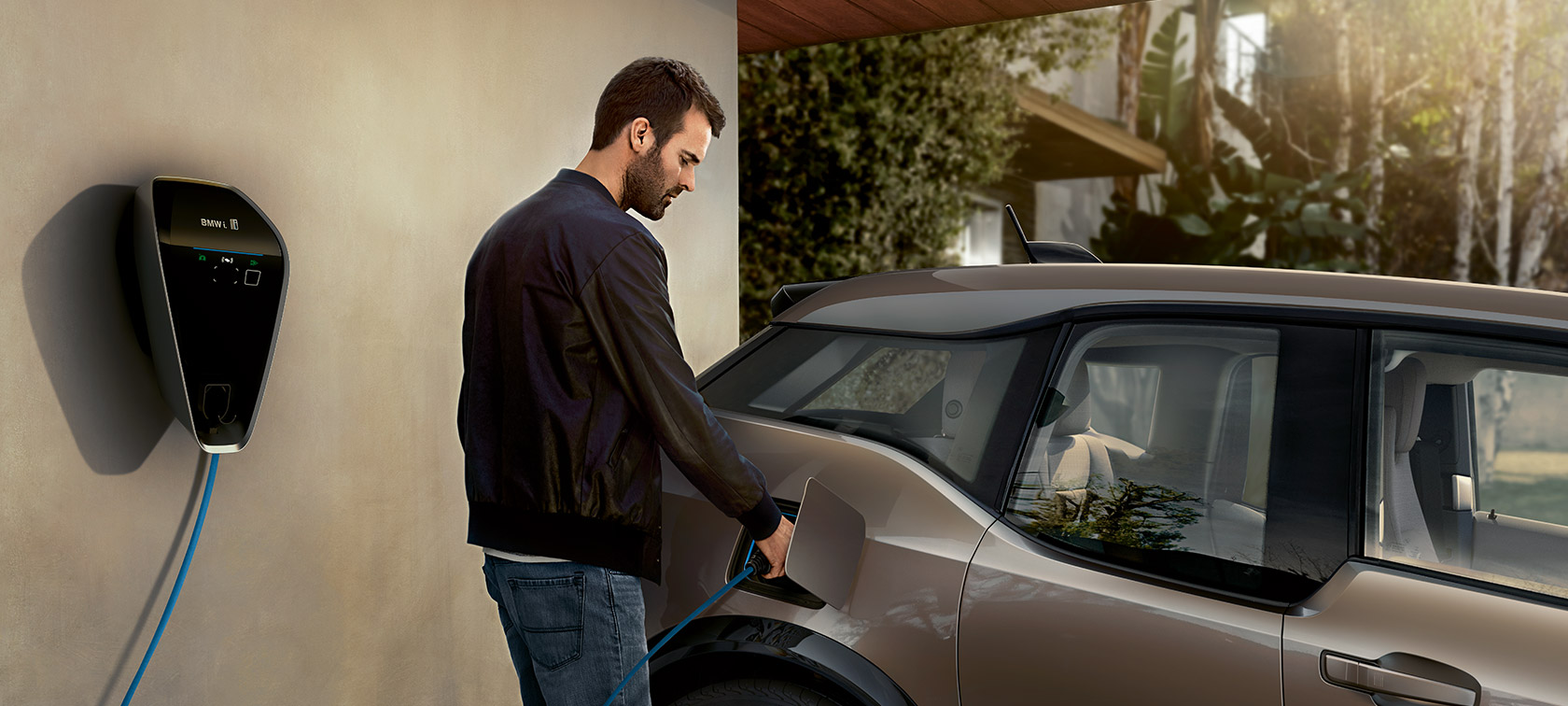 Mężczyzna ładujący BMW i3. Mężczyzna ładujący BMW i3 z BMW i Wallbox.