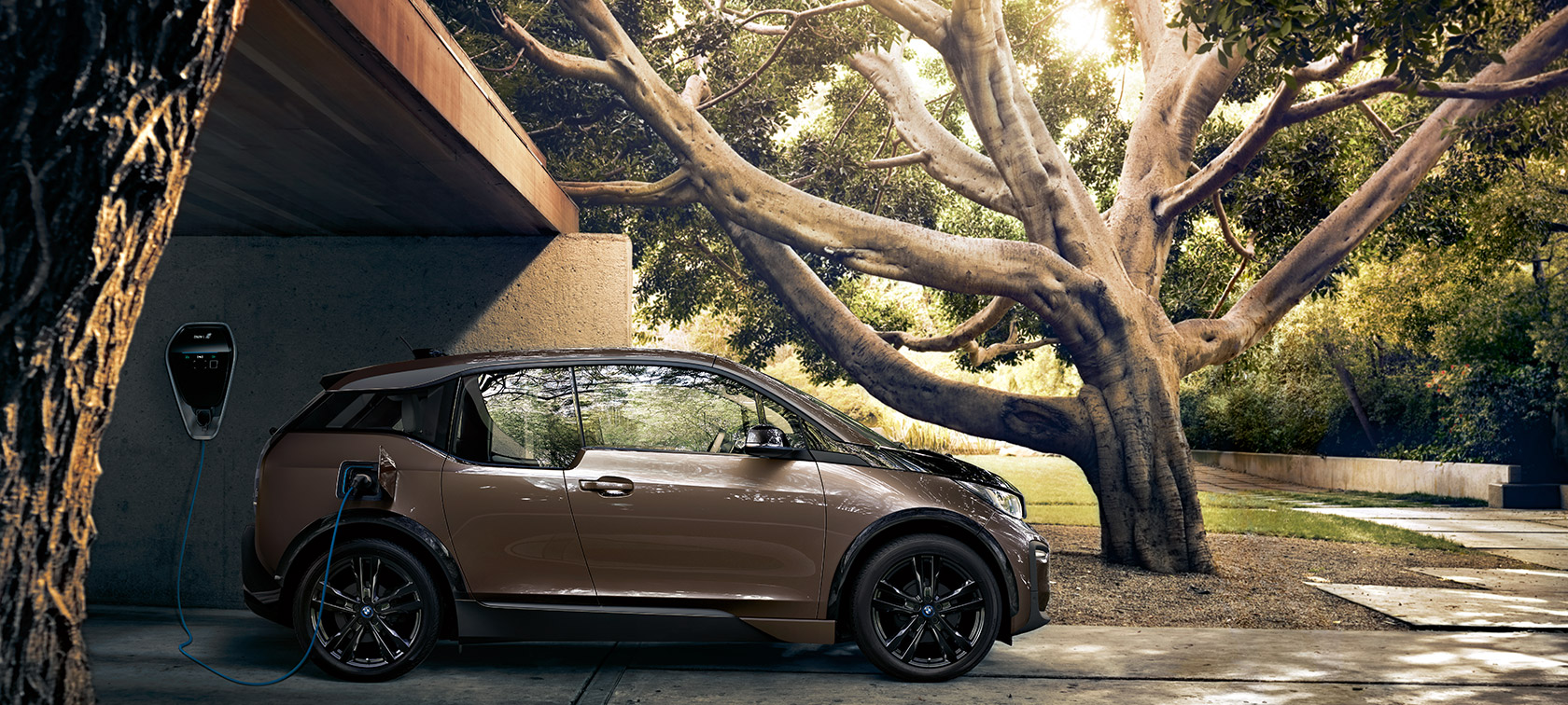 BMW i3s z BMW i Wallbox BMW i3s widziany z boku z BMW i Wallbox w naturalnym otoczeniu.