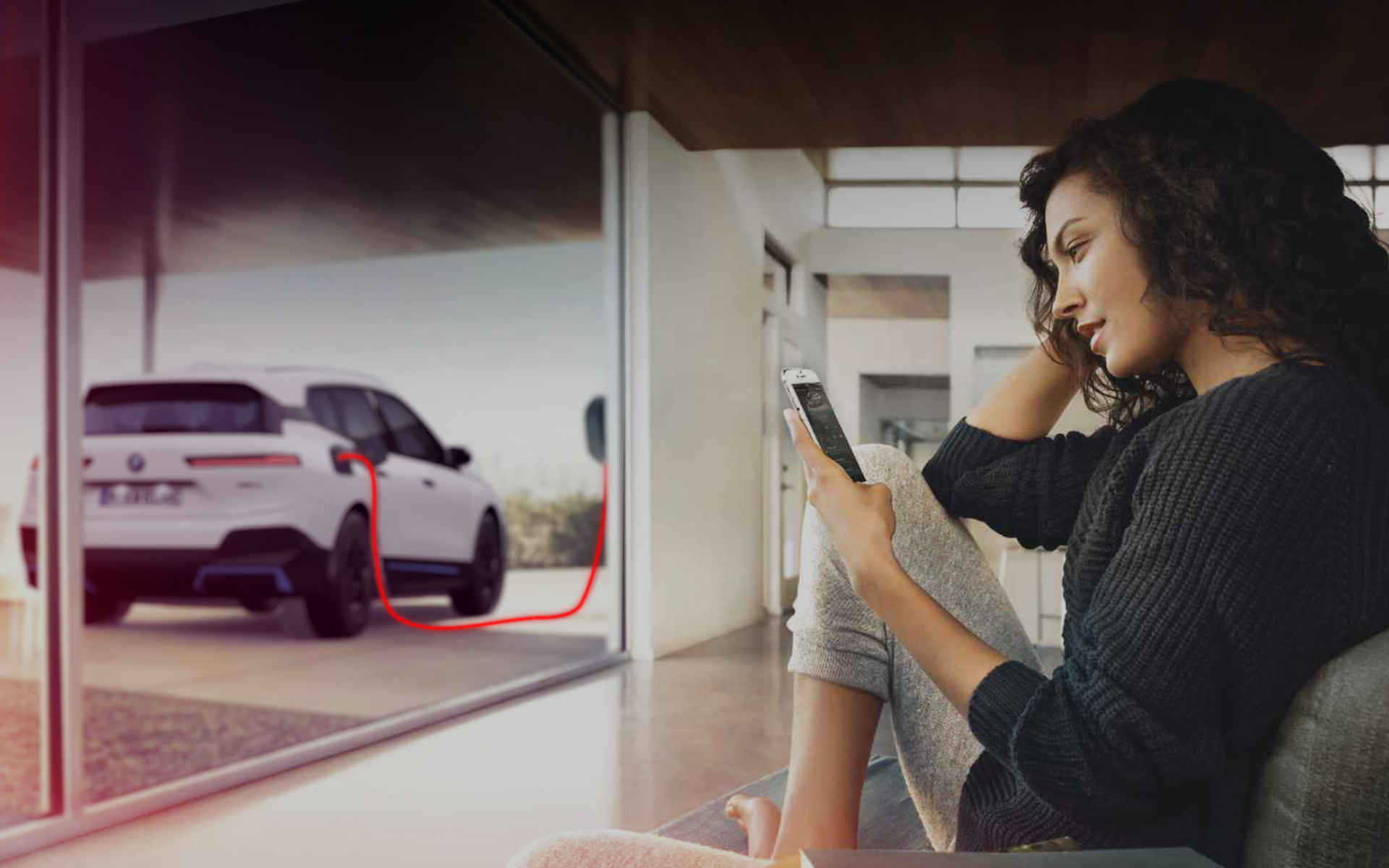 Ładowanie w domu BMW iX i20 kobieta ze smartfonem