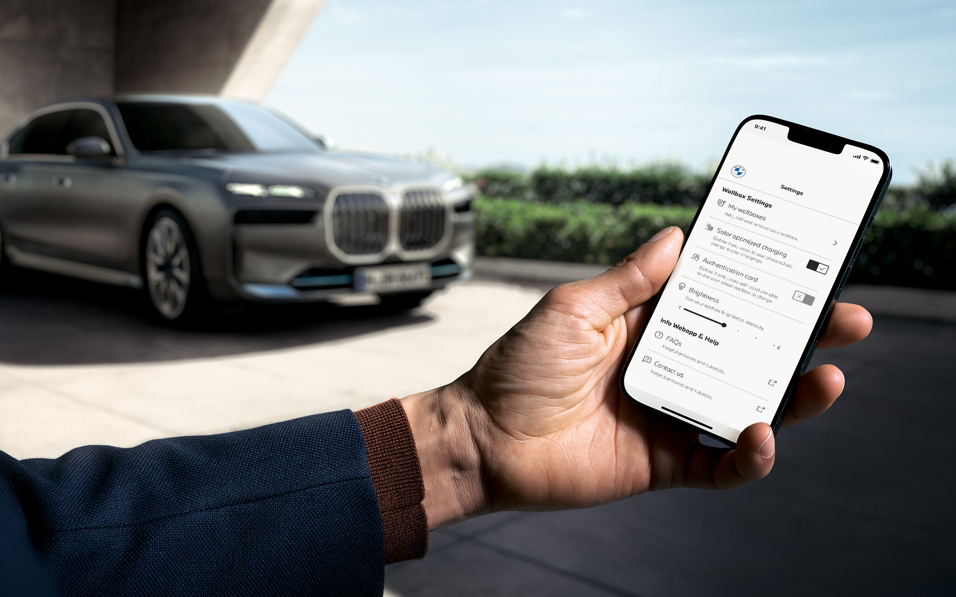 BMW i7 G70 smartfon na pierwszym planie pokazuje aplikację My BMW