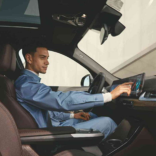 Connected Charging w samochodzie mężczyzna obsługuje zakrzywiony wyświetlacz BMW