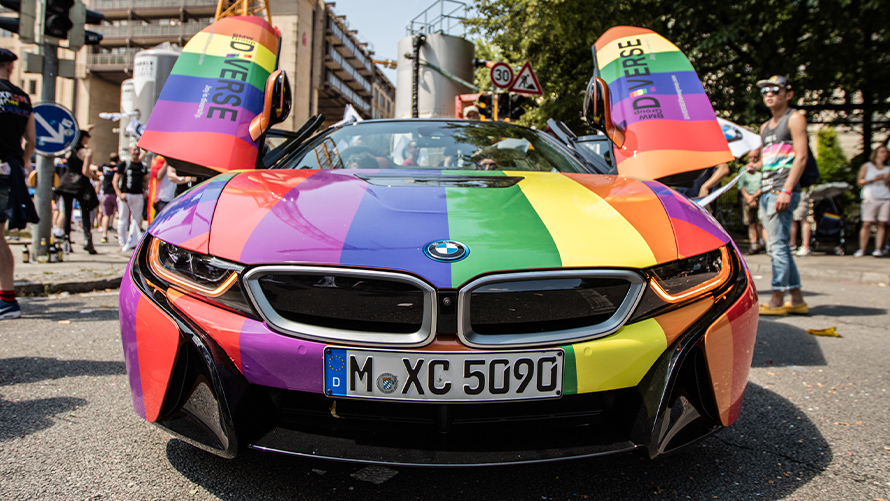 Różnorodność zrównoważony rozwój BMW Zrównoważony rozwój różnorodność pojazd BMW widok z przodu w kolorach tęczy z otwartymi drzwiami