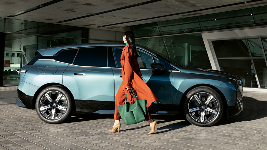 Korzystanie z BMW Digital Key BMW Digital Key korzystanie BMW iX i20 widok z boku z kobietą na pierwszym planie