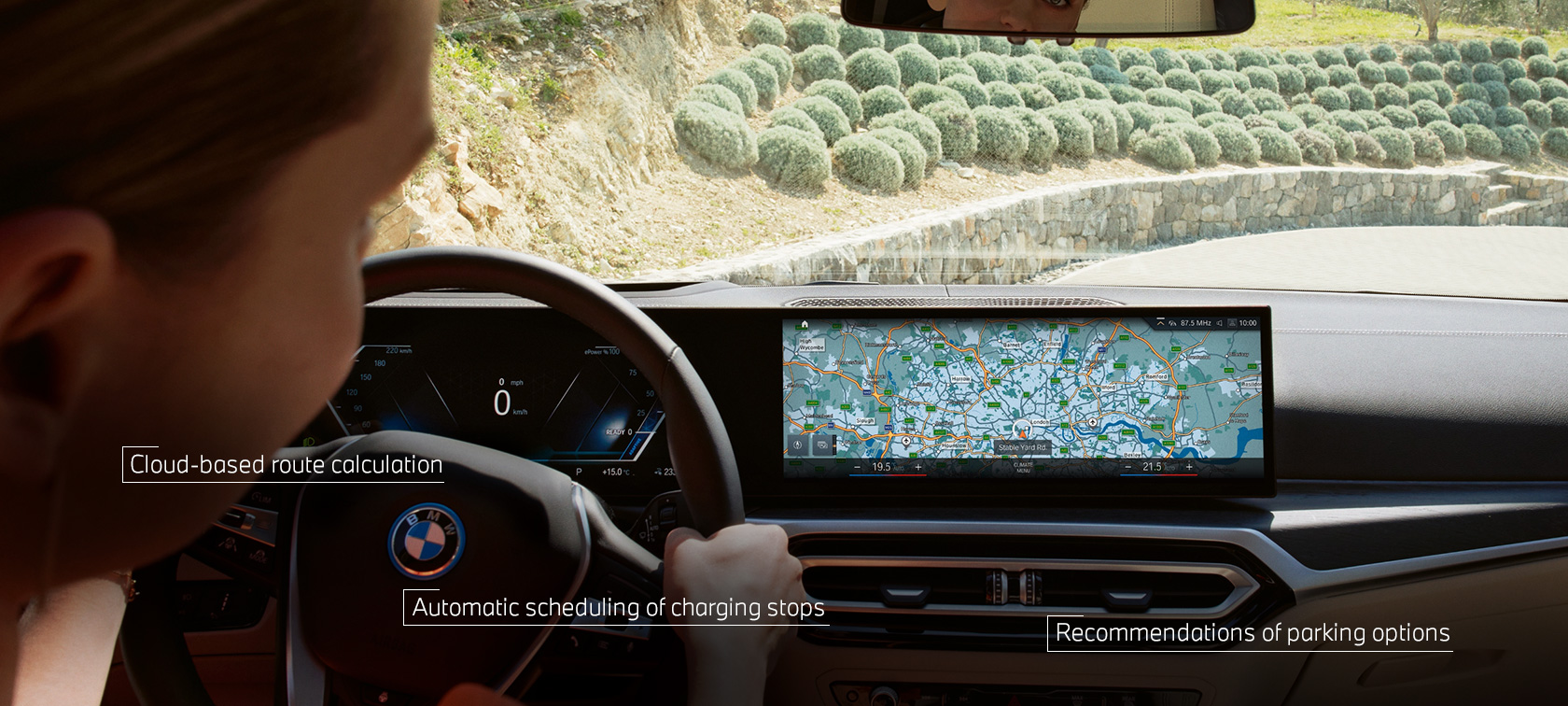 Mężczyzna za kierownicą swojego BMW śledzi wskazówki nawigacyjne z BMW Maps na wyświetlaczu centralnym Mężczyzna za kierownicą swojego BMW śledzi wskazówki nawigacyjne z BMW Maps na wyświetlaczu centralnym