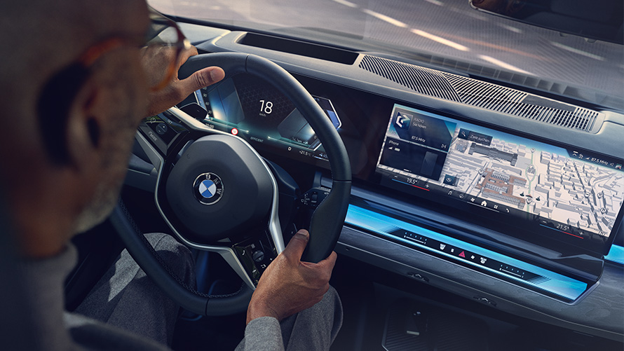Wnętrze BMW mężczyzna patrzy na wyświetlacz z BMW Operating System 8.5 Wnętrze BMW mężczyzna patrzy na BMW Maps na wyświetlaczu z BMW Operating System 8.5