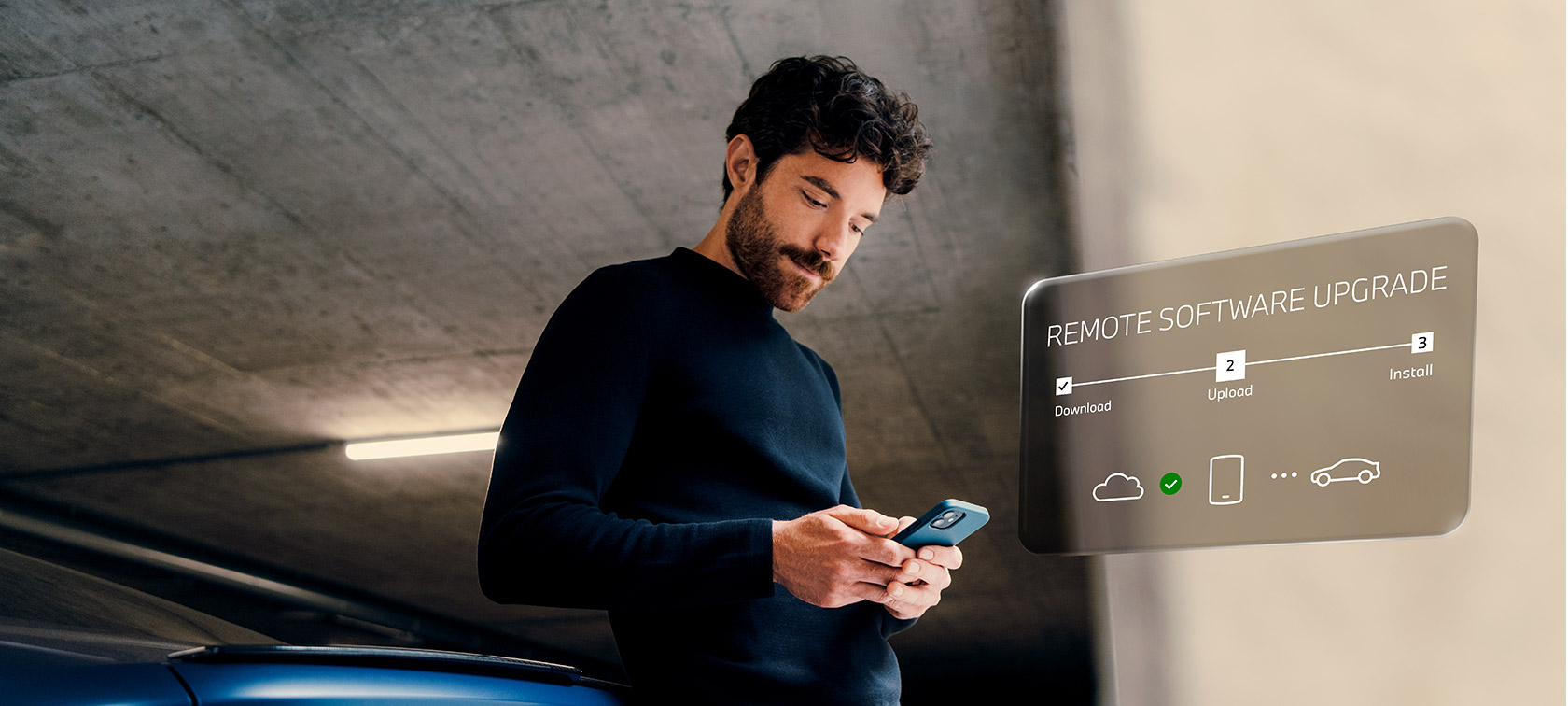 Mężczyzna przed BMW patrzy na swój smartfon Zdalna aktualizacja oprogramowania mężczyzna przed BMW patrzy na swój smartfon