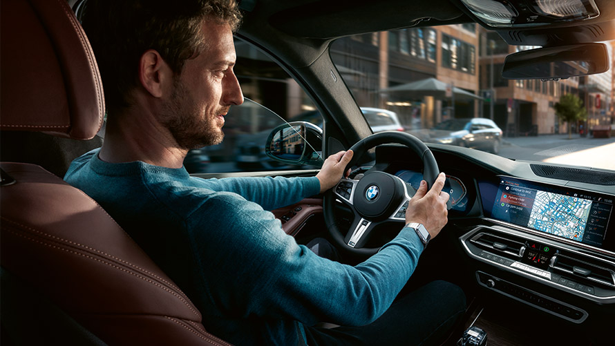Asystent Parkowania Mężczyzna używa Asystenta Parkowania na wyświetlaczu BMW