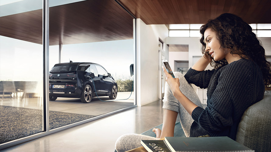 Digital Charging Service Kobieta używa “Digital Charging Service“ dla jej BMW i3 w domu na swoim smartfonie