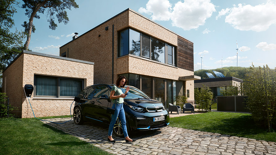 Digital Charging Service Kobieta używa “Digital Charging Service“ dla jej BMW i3 w domu na swoim smartfonie