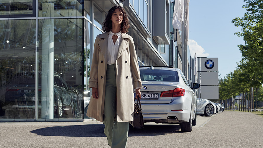 BMW Service Inclusive Kobieta przed salonem BMW