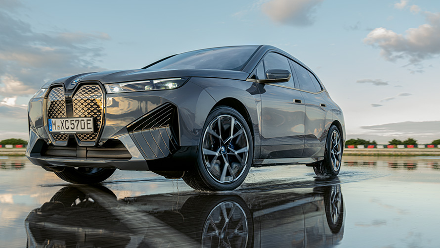 Obręcze kół BMW, przedni półprofil BMW iX (i20) na mokrej nawierzchni Obręcze kół BMW, przedni półprofil BMW iX (i20) na mokrej nawierzchni