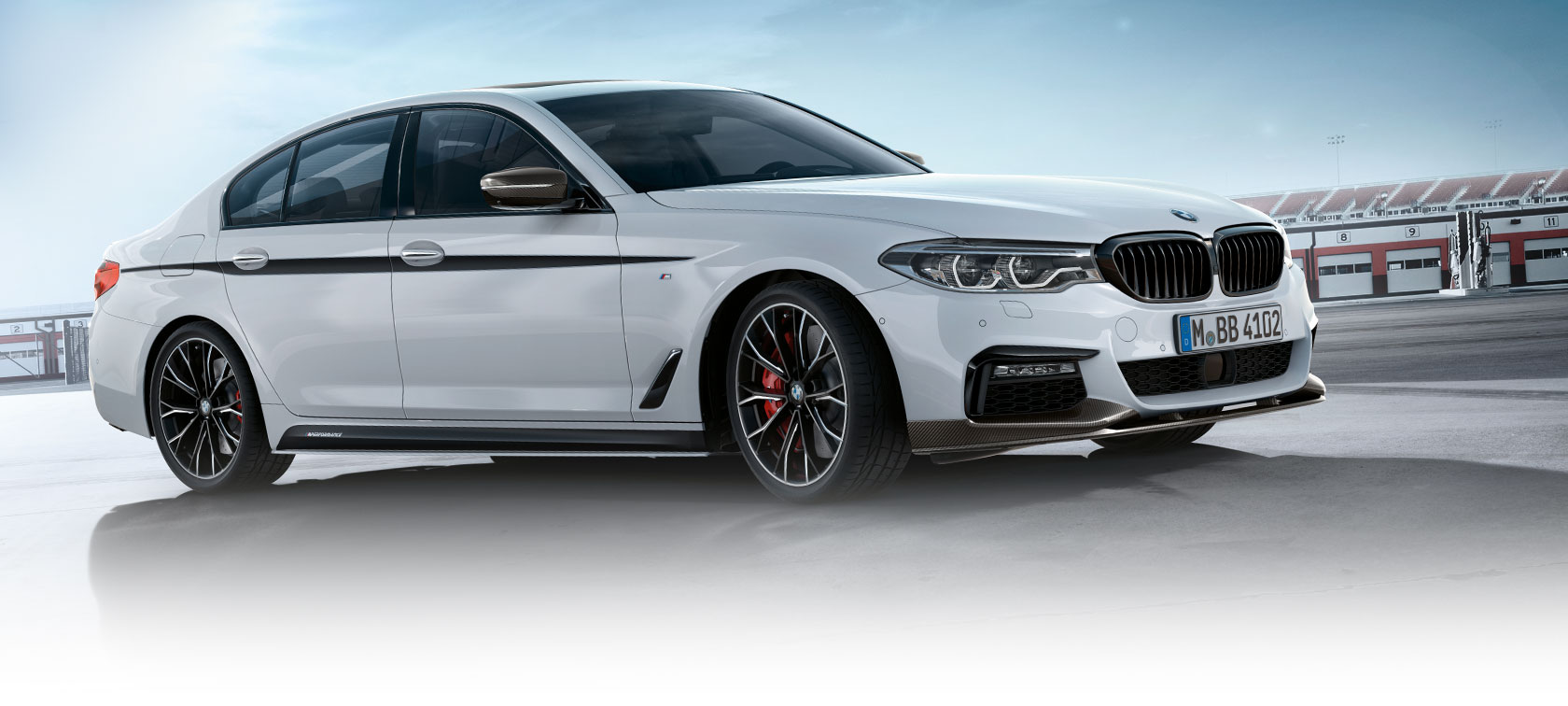 BMW serii 3 Limuzyna, M Performance Parts. Widok z boku BMW serii 3 Limuzyna na parkingu z błękitnym niebem.