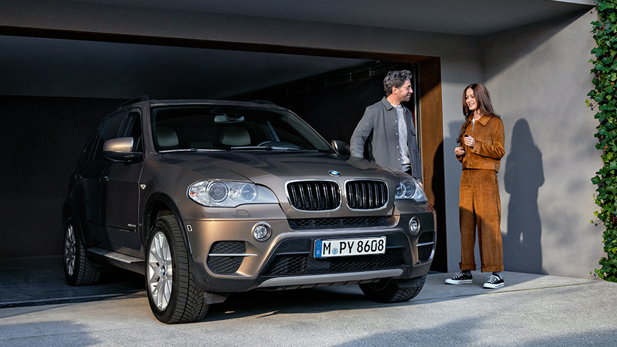 BMW stojące przed garażem z modelami BMW Value Service BMW stojące przed garażem z modelami