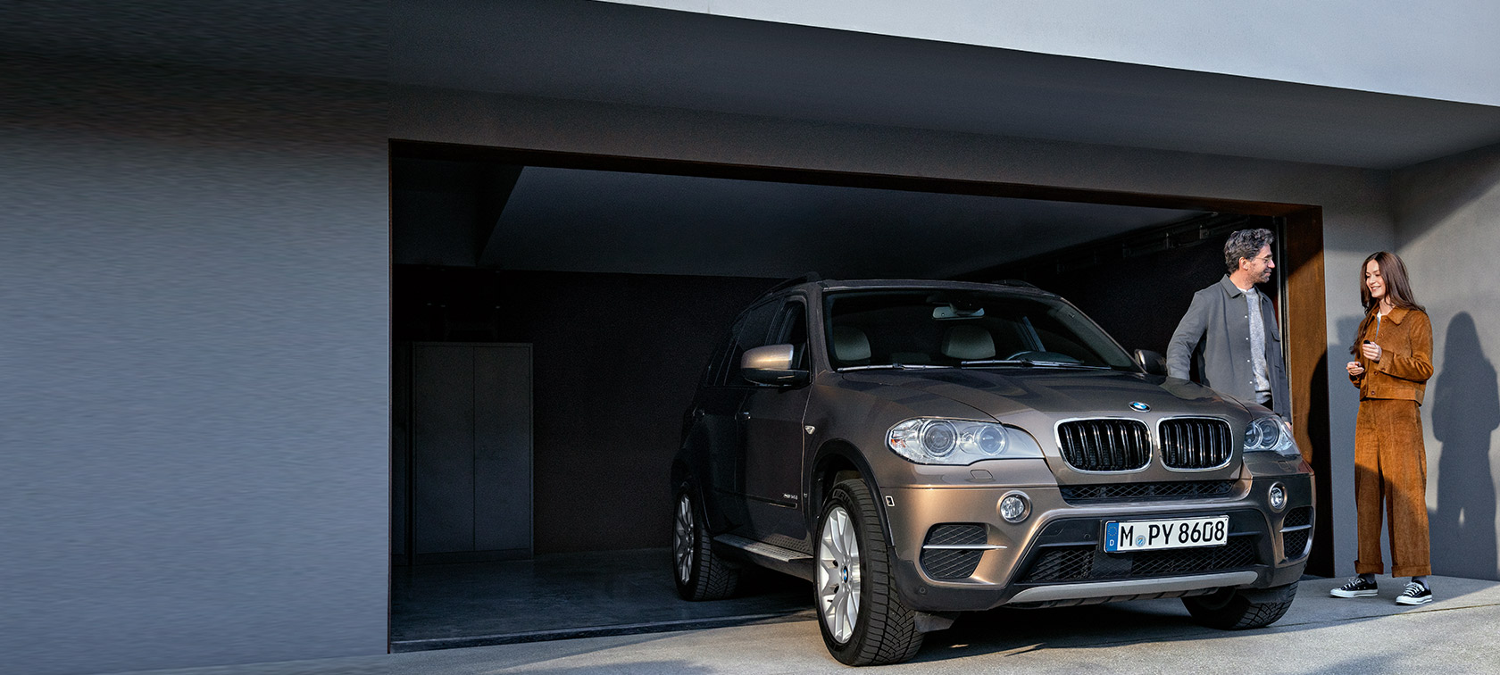 BMW Value Service BMW Value Service mężczyzna i kobieta przed garażem z BMW X5