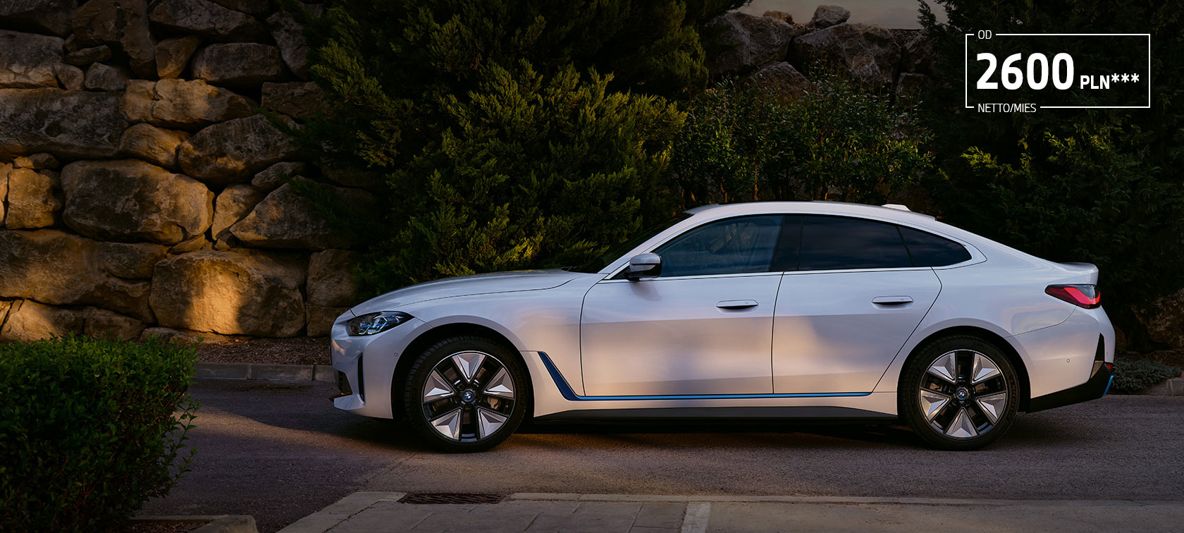 BMW i4 eDrive40 G26 2021 biel mineralna przedni półprofil podczas postoju na tle jeziora i wzgórza